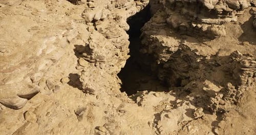 Exploring Rocky Formations and Crevices in a Desert Landscape at Midday