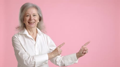 Happy Senior Woman Pointing to Copy Space Suggesting for Advertisement or Text