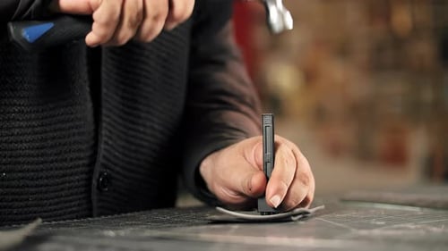 Craftsman Hammering Pricking Chisel to Make Stitching Holes in Leather