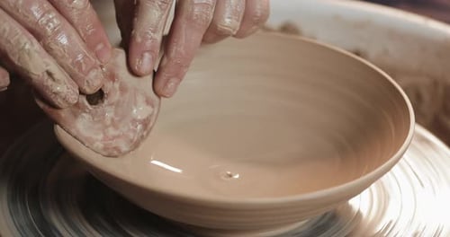 Potter au tour de potier fabrique un produit en céramique à l'aide de ses mains et de ses outils de poterie Gros plan