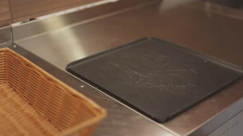 The baker puts the baked aromatic bread with a crispy crust on the cutting board. Bread production.