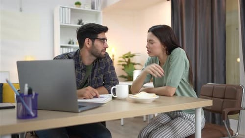 Couple Discussing Content on Laptop at Home