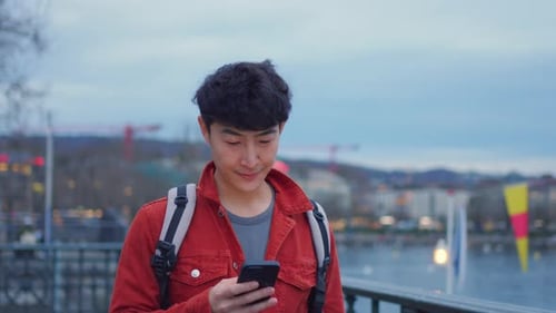 Asian attractive man backpacker walking around beautiful road in city.