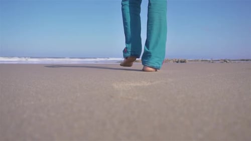 Man geht barfuß am Sandstrand an der sonnigen Meeresküste spazieren, Natur, Zeitlupenreisen im Freien