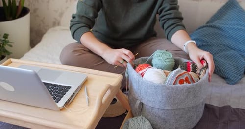 Woman Crocheting At Home on Bed