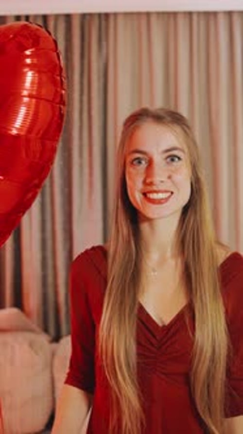 Smiling Woman Holding Heart Balloon Inside