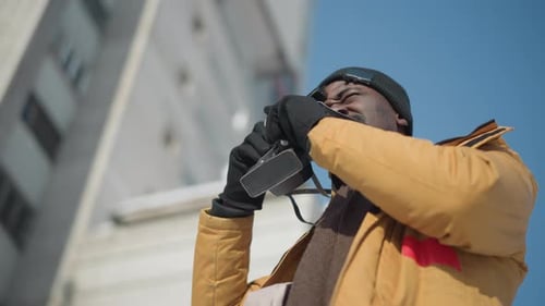 Man Taking Pictures With Vintage Camera Outdoors