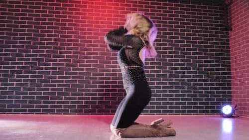 Blonde Woman Kneeling Down and Dancing in Studio