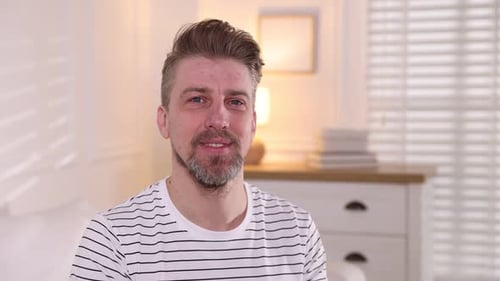 Hombre sonriente mostrando un gesto de silencio en casa