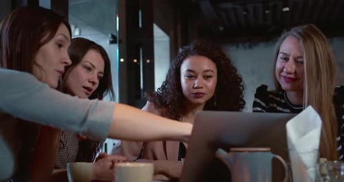 Young Caucasian Female Leader Uses Laptop to Work with Colleagues Speaks and Points at Display to