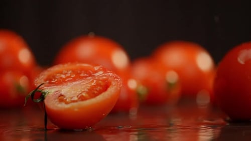 A Whole Tomato Falls on a Wet Surface From Which Splashes are Formed