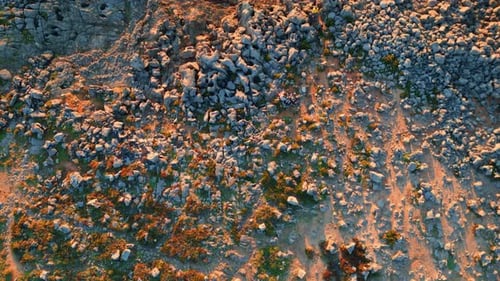 Turquoise ocean waves washing rocky seashore cliffs on a sunny day aerial view