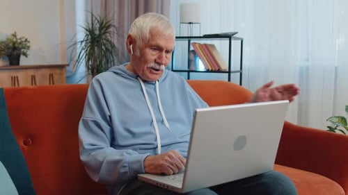 Senior Man Video Calling on Laptop Indoors