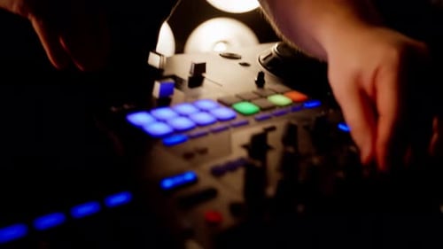 DJ Mixing Music on Sound Board in Club