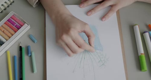 Nahaufnahme einer weiblichen Hand mit Buntstift, Zeichenpflanze im Skizzenbuch, die zu Hause am Tisch arbeitet und Spaß hat