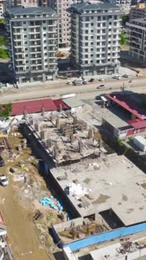 Vídeo vertical Maquinaria pesada y constructores colaboran activamente en la obra de cimentación de un nuevo