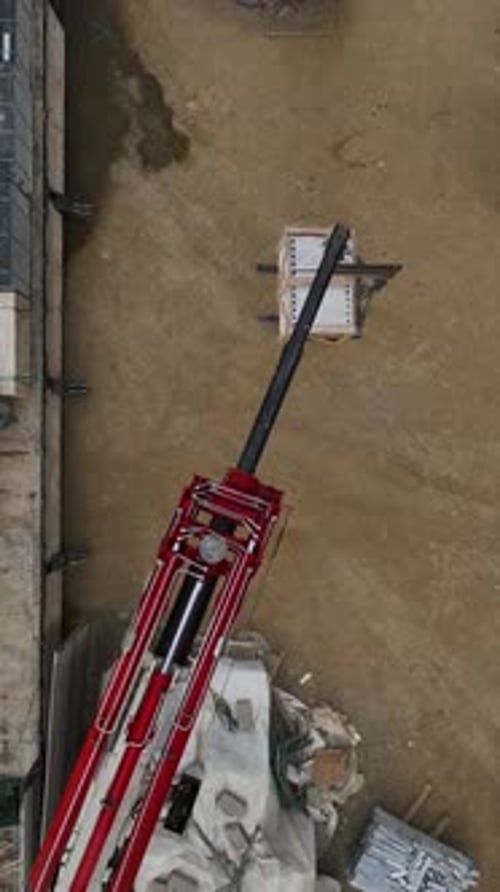 Vertical Video Above the Building Activity Aerial View of Crane Unloading Builders at Work