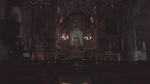 nobody inside ancient catholic church moving forward past empty benches towards the holy alter gold