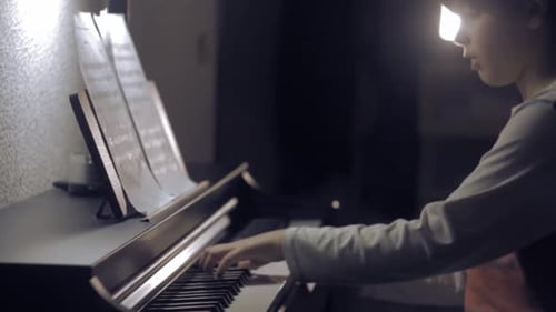 Child Playing Piano at Home at Night