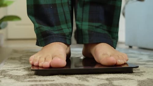 Bare Feet Step Onto Scale in Home Interior