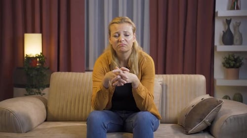 Distraught Woman Talks While Sitting on Couch