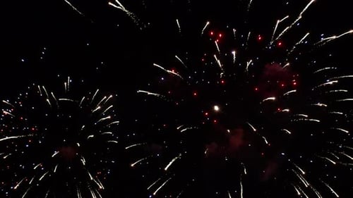 Rotes und weißes Feuerwerk erhellt den dunklen Himmel über dem Lake Estes