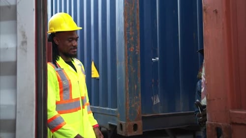 Man Inspects Metalwork in Industrial Setting