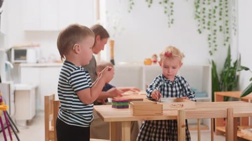 Boy With Hearing Aid Stacks Tiles During Preschool Session