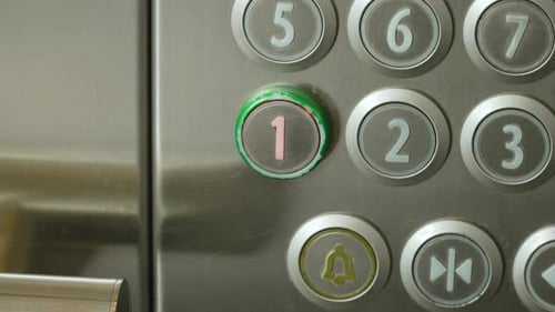 Runde Metallknöpfe mit Etagennummern in der Aufzugskabine während der Fahrt