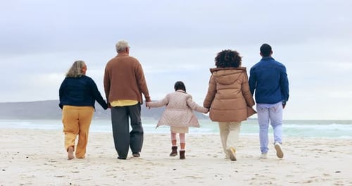 Big family on beach, holding hands and parents with child, grandparents