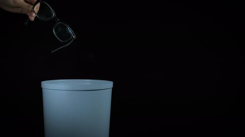 Black Frame Glasses Dropped in Trash Can