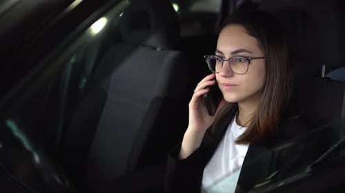 Woman in Car Talking on Phone at Night