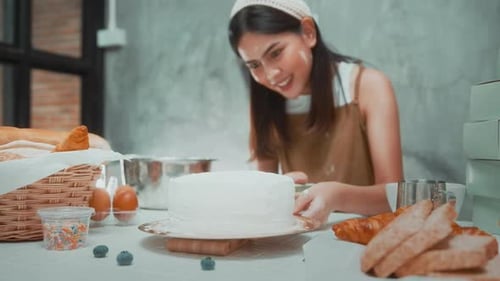 Woman Decorating a Cake in Her Kitchen