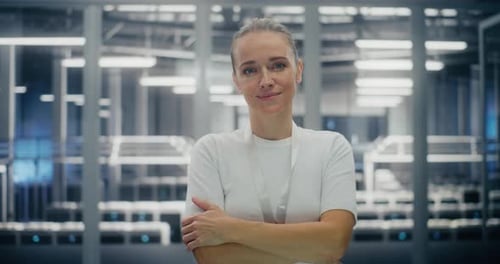 Young Woman Standing in Middle of Secure Modern Data Center