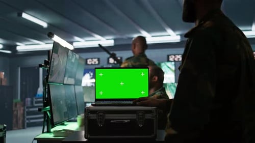 Soldier Using Tracking Software on Green Screen Laptop to Gain Info Against Enemies