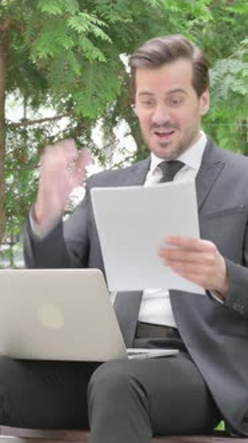 Happy Businessman Working on Laptop Outside on Park Bench