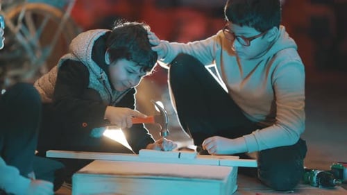 Children Working on a Woodworking Project at Night