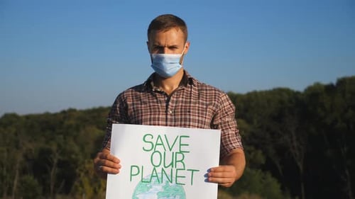 Man Holds Save Our Planet Sign Outdoors