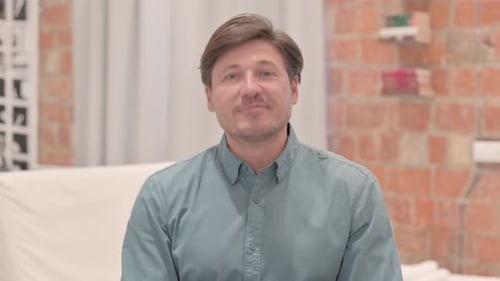 Man Speaking and Giving Thumbs Up Indoors