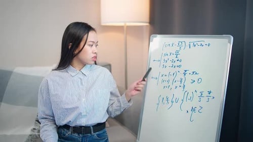 Math Teacher Explains Equations on Whiteboard