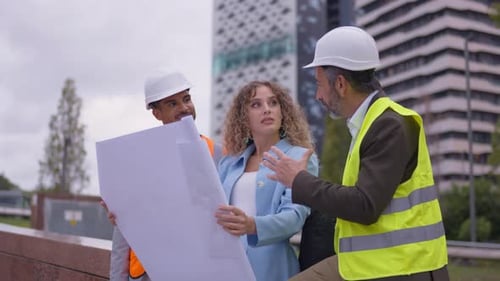 Construction Team Reviewing Blueprints at Building Site
