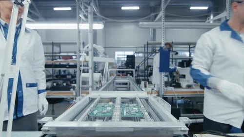 Zeitraffer von Arbeitern in einer Elektronikfabrik, die Leiterplatten von Hand zusammenbauen, während sie sich auf der A bewegen