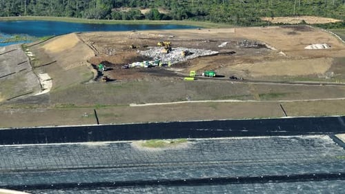 Aerial View of Landfill Site with Garbage Trucks