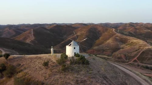 aerial footage of a windmill on a hill. wind power plant. video of hills and wind resources as energ