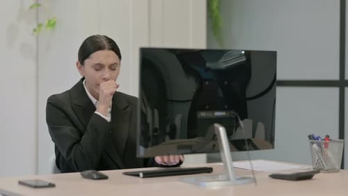 Woman Coughing While Working At Her Computer