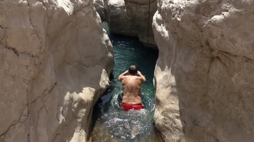Man jumps and swims in exotic natural pool super slow motion summer adventure