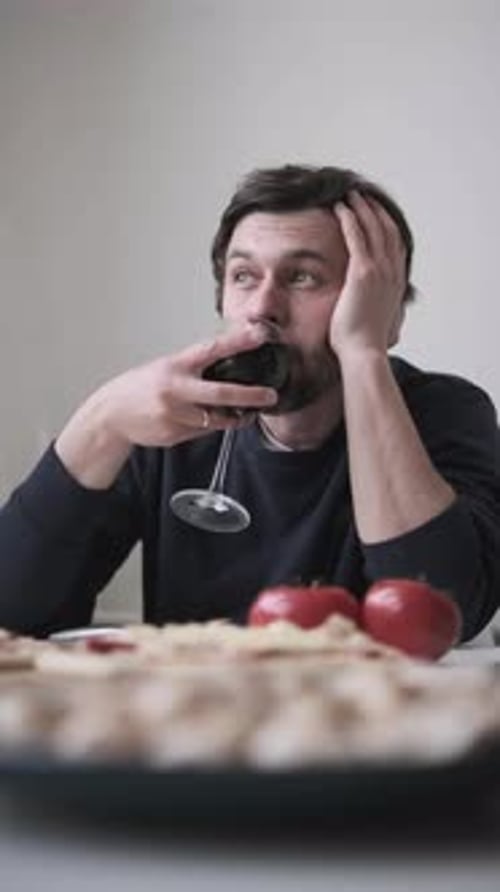 Man with Pizza and Wine is Contemplative