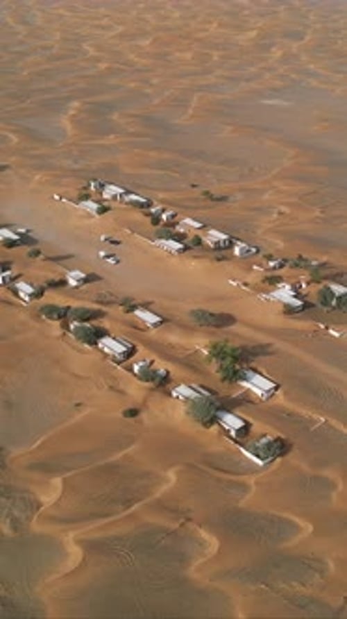 Aerial view of abandoned houses in the UAE desert near Dubai, overtaken by sand dunes