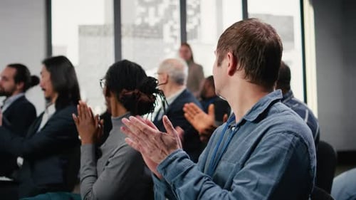 Audience Members Applaud at Business Presentation in Conference Room