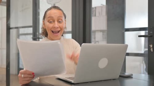 Woman Excited About Computer at Office Desk